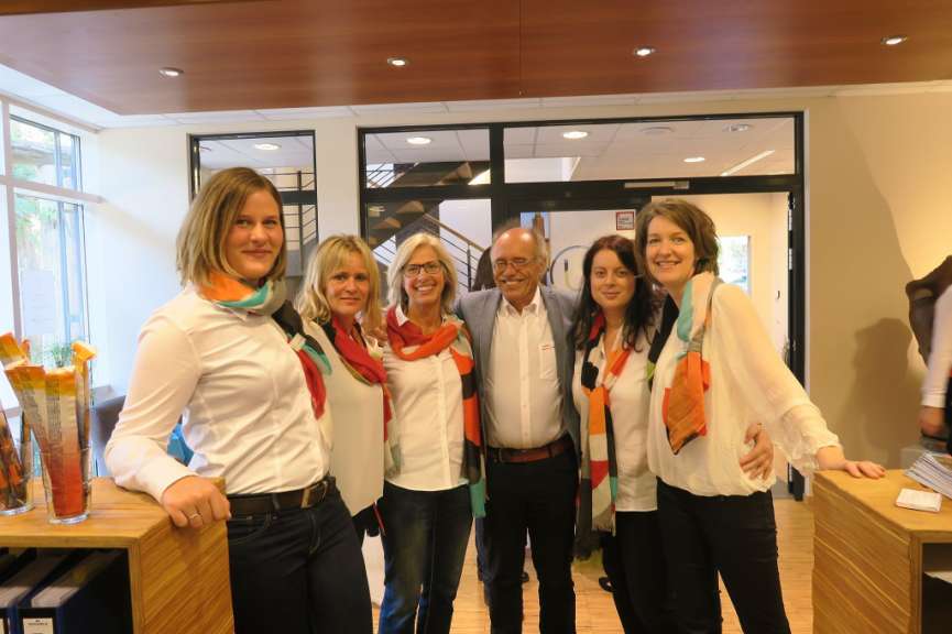 Eine Gruppe von Menschen posiert für ein Foto mit einem Mann in einem weißen Hemd mit der Aufschrift ' sparkasse ' darauf