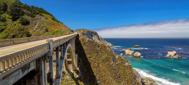 Pacific Coast Highway One Ein Auto fährt auf einer Brücke über den Ozean