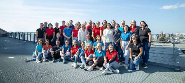 Eine Gruppe von Menschen posiert für ein Foto auf einem Dach
